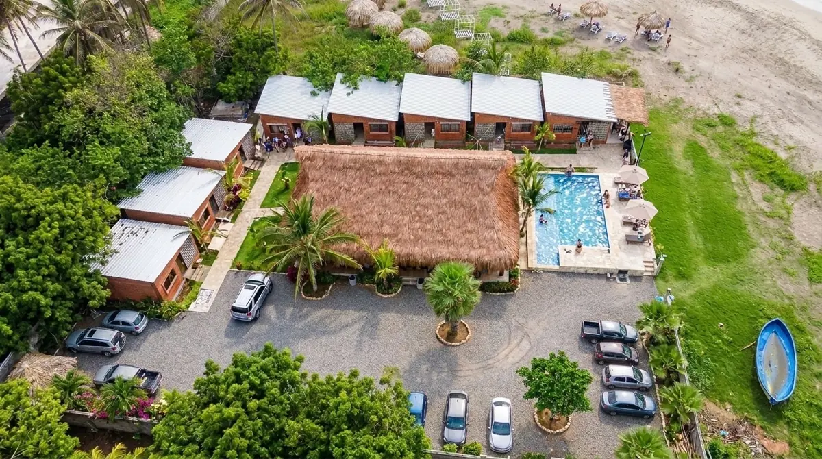 Vista aérea de Mokano: la gran palapa, la piscina y las cabañas frente a la playa de Palmarito